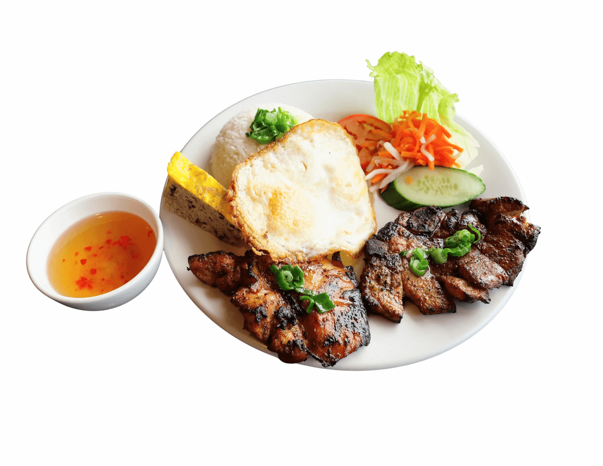 Grilled pork chop on jasmine rice with a fried egg, salad and fish sauce